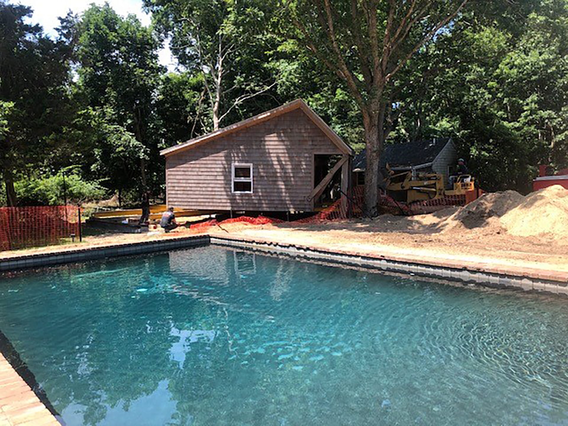 Shed during the process of relocation next to a pool, after it has been taken off the track loader.